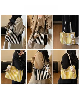 Detail view of striped canvas tote bags with cute bear charm for daily casual wear