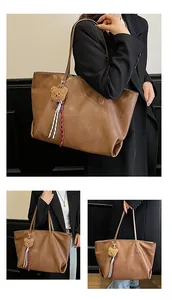 Dettaglio macro della trama in pelle marrone liscia e della lucentezza della borsa tote