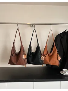 Detail view of large commuter tote bags in dark coffee, black, and caramel colors
