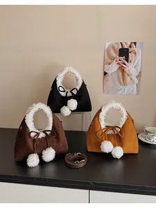 Three plush dumpling handbags in black, brown, and yellow with fluffy fur pom-poms