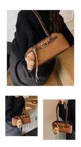 Detailed macro view of vintage brown shoulder bag with metal buckle and plush bear charm