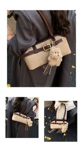 Close-up of retro color-block tote with gold buckle and plush dog charm in autumn setting