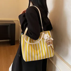 Striped canvas tote bag with leather straps and cute bear charm for daily wear