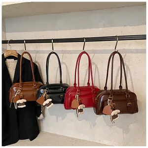 Detail view of retro Boston bags in four colors with heart and bear charms