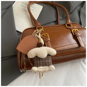 Close-up of vintage brown PU leather Boston bag with plush charm and gold hardware