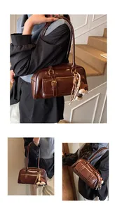 Detail of dark brown vintage underarm bag featuring glossy leather and heart charm