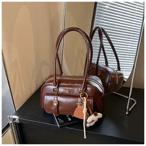 Detail view of dark brown vintage boston bag with glossy finish and double handles