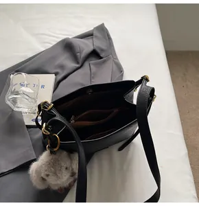 Detailed view of the internal compartments and brown lining of a black leather tote bag