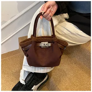 Detail of dark brown suede bucket bag with faux fur trim and silver metal twist lock