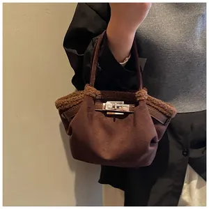 Close-up of brown suede bucket bag featuring faux fur trim and silver turn-lock closure
