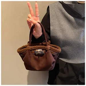 Detail of a brown suede bucket bag with faux fur trim and silver turn-lock closure