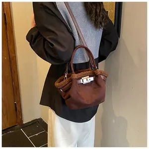 Detailed view of dark brown suede bucket bag with plush shearling trim and metal clasp