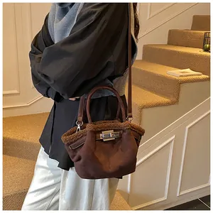 Brown suede bucket bag with plush trim and metal twist lock shown in a lifestyle setting