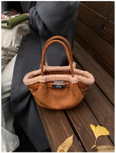 Detailed shot of brown suede bucket bag with soft fleece trim and silver turn-lock clasp