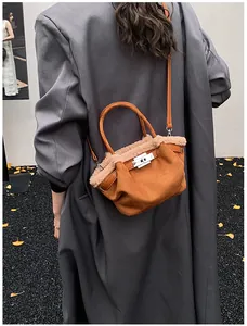 Close-up of caramel suede bucket bag with faux fur trim and silver twist lock detail