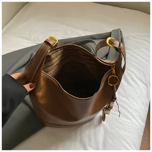 Draufsicht auf das Innere einer braunen Leder-Eimertasche mit gestreiftem Futter