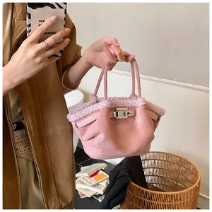 Pink suede bucket bag with fluffy shearling trim and silver metal twist lock closure