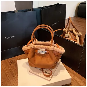 Brown suede bucket bag with cream shearling trim and silver rotating metal lock detail
