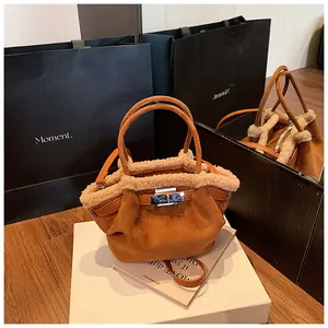 Detail of suede bucket bag with shearling trim and silver rotating lock closure