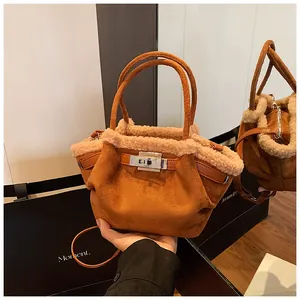 Macro detail of caramel suede bucket bag with plush shearling trim and metal buckle