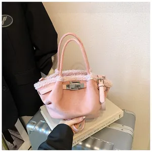 Detailed close-up of pink suede bucket bag with soft faux fur trim and metal clasp