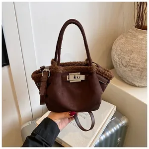 Detailed close-up of brown suede and faux shearling bucket bag with silver twist lock