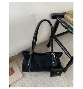 Dettaglio borsa a spalla in camoscio nero con borchie metalliche e mini custodia decorativa