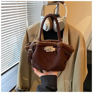 Detail of plush brown bucket bag with fleece trim and silver metal twist lock closure