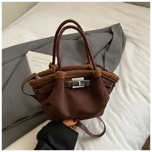 Detail of dark brown suede bucket bag featuring teddy shearling trim and silver turn-lock