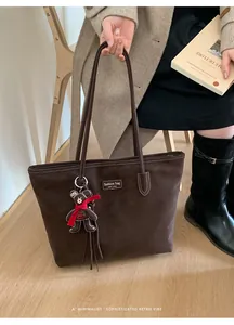 Detail of coffee tote bag with New York label and brown plush bear charm