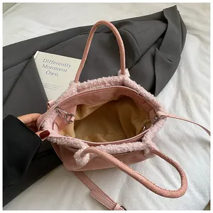 Detail of pink faux shearling bucket bag with leather trim and beige fabric lining