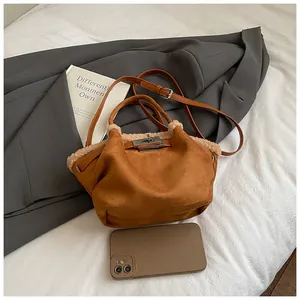 Close-up of brown suede bucket bag with beige faux fur trim and silver turn-lock closure