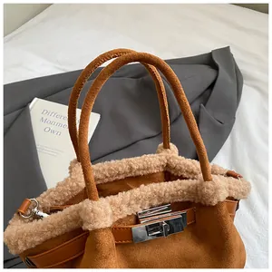 Detail of caramel suede bucket bag featuring creamy faux fur trim and silver turn-lock