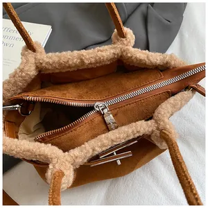 Detail of caramel suede bucket bag featuring plush cream fleece trim and metal zipper