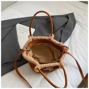 Detail of caramel brown bucket bag featuring beige faux fur trim and matte leather finish