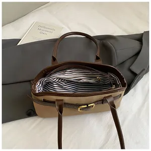 Detail of the khaki shoulder bag showing striped lining and internal zipper pocket