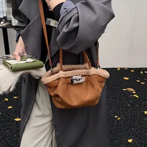 Chic brown suede bucket bag with plush trim and silver lock, worn by a model in autumn