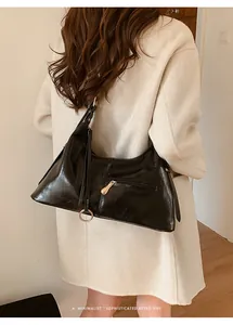 Sac fourre-tout noir chic avec texture plissée et zip métallique porté à l'épaule