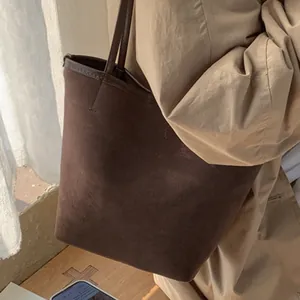 Minimalist large brown suede bucket bag with slim shoulder strap for daily commuting