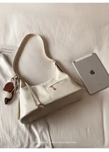 Détail du sac hobo blanc crème avec ferrures dorées et breloques mignonnes