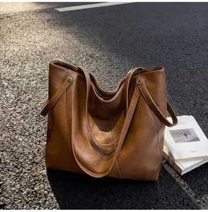 Outdoor shot of caramel brown leather tote bag showing texture and strap details