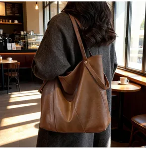 Detailed view of the large brown tote bag showing its soft leather texture and strap