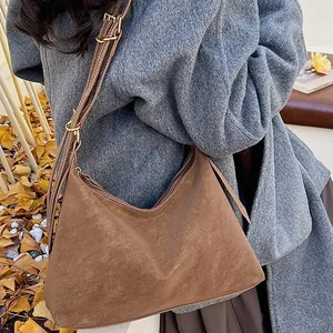 Brown suede tote bag for women featuring adjustable shoulder straps in an autumn setting