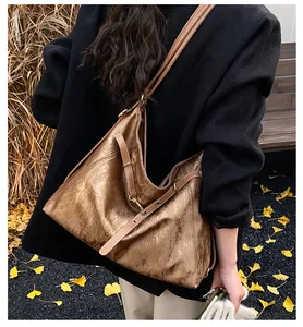 Detail of golden brown metallic tote bag with faux leather strap in autumn setting