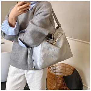 Close-up of the silver metallic tote bag featuring textured PU fabric and long shoulder strap