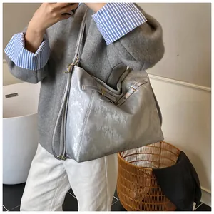 Mirror selfie showing the large silver tote bag with metallic texture and sleek shoulder straps