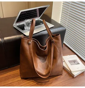 Detailed macro view of brown leather texture and silver rivet on a large tote bag