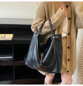 Detailed side view of the black tote bag showing its smooth texture and large capacity