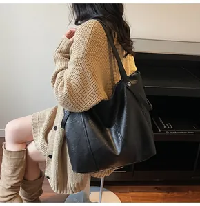 Close-up of the large black tote bag showing its soft leather texture and matte finish