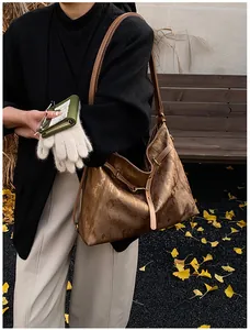 Close-up of metallic bronze tote bag with brushed texture and gold hardware details